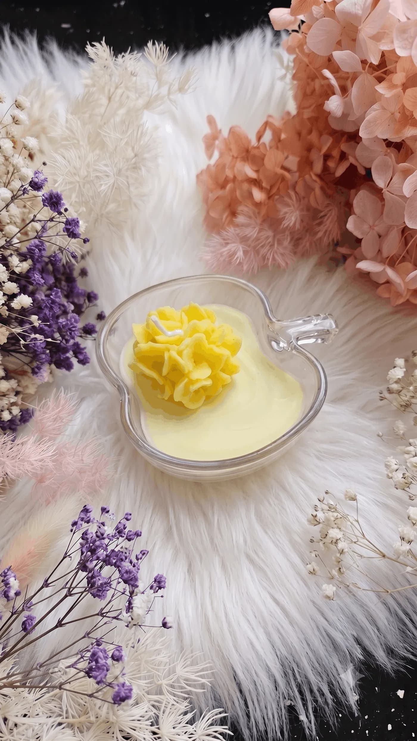 Yellow flower candle in a clear apple-shaped vessel