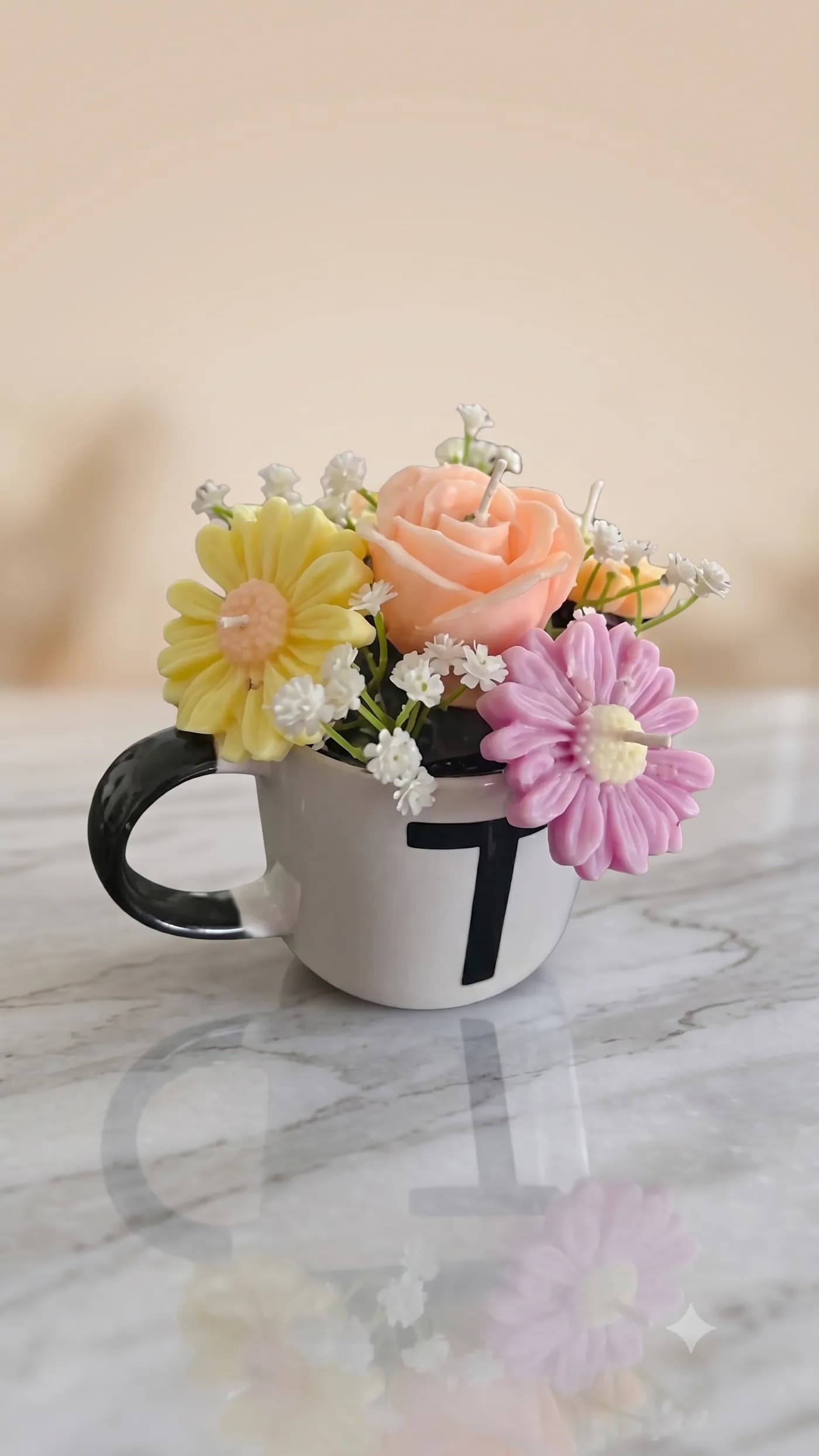 Peach rose and daisy candle arrangement in a two-tone mug