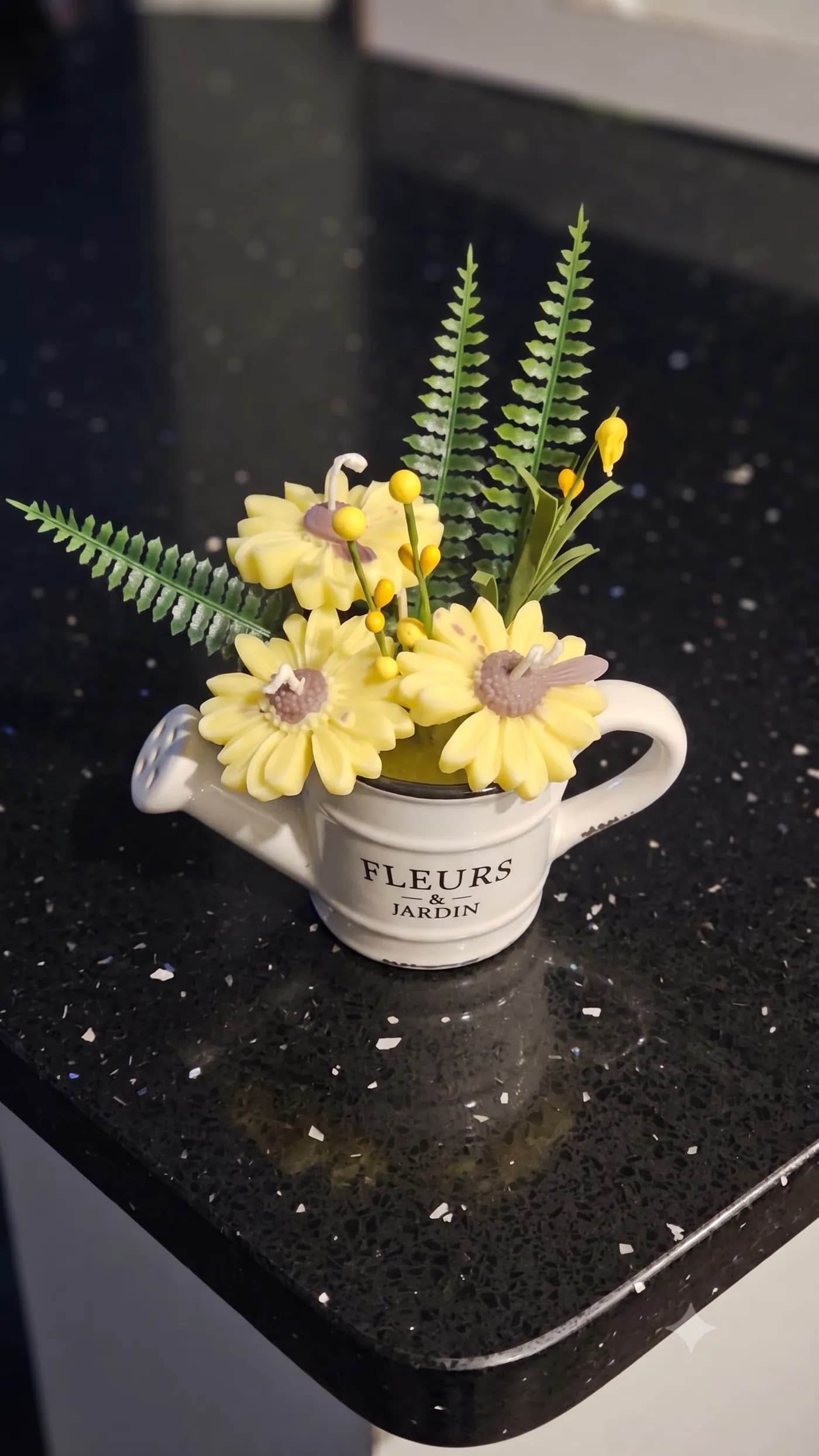 Yellow floral candle arrangement in a white watering can